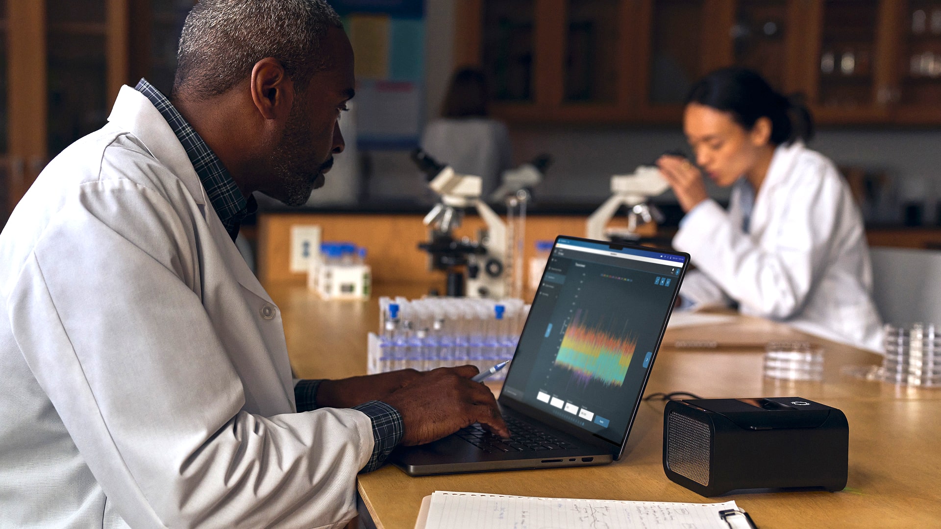 A person uses an M4 MacBook Pro on a desk.
