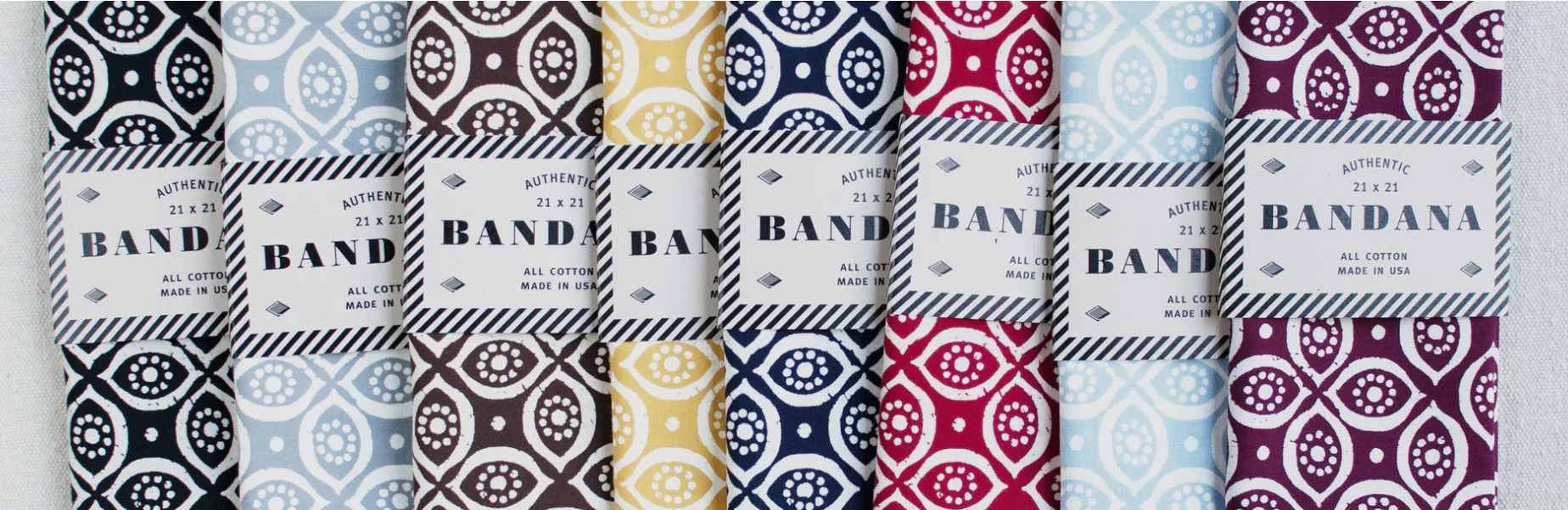 Row of eight screen-printed bandanas packaged with the Bandana logo.