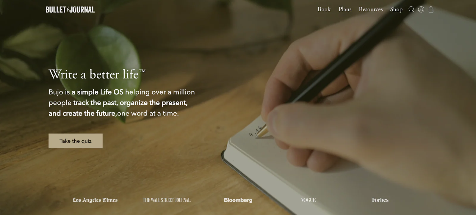 Bullet Journal homepage showing a person writing in a journal.