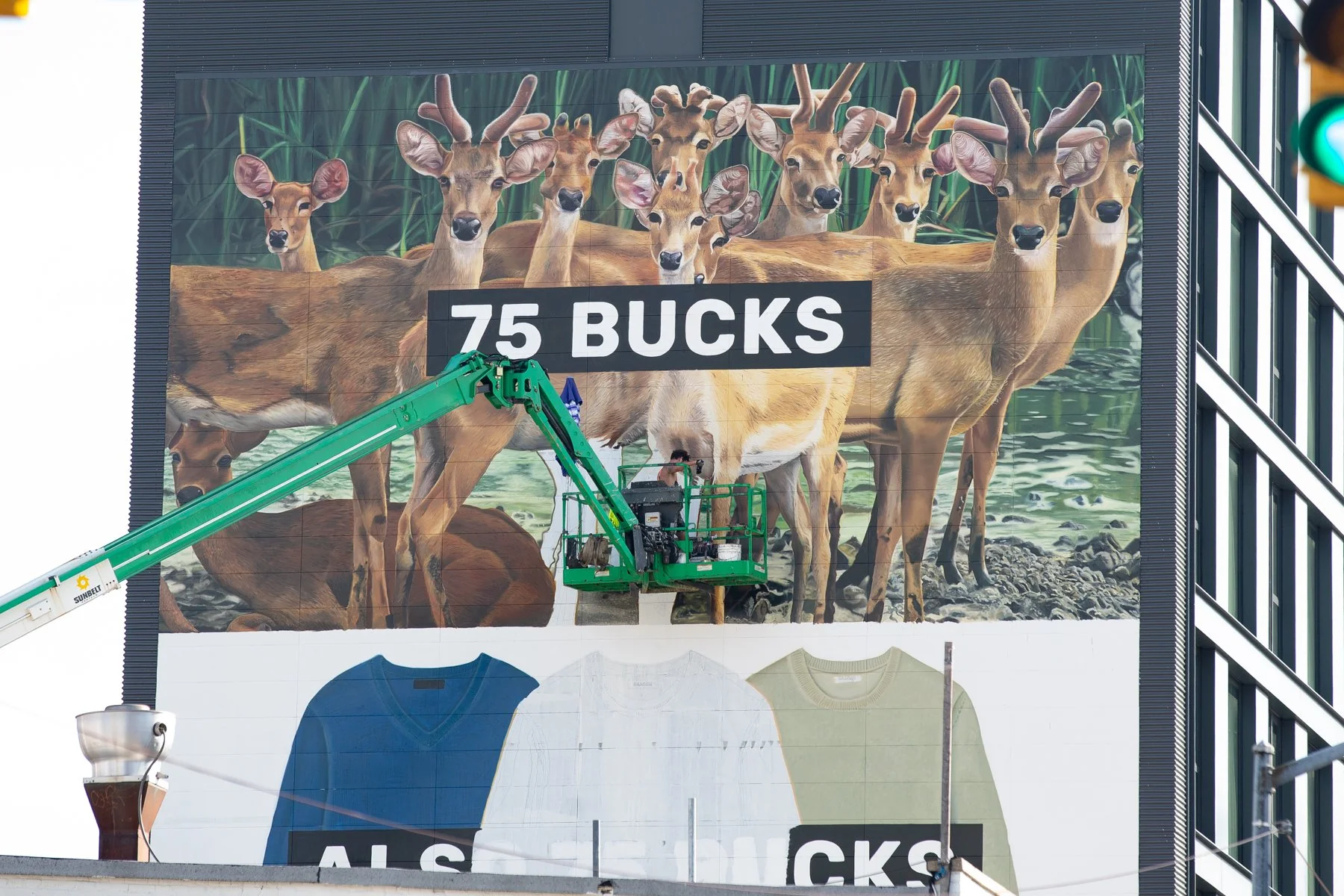 Mural by Colossal Media with deer that reads ‘75 Bucks’ above sweaters that read ‘also 75 bucks.’.