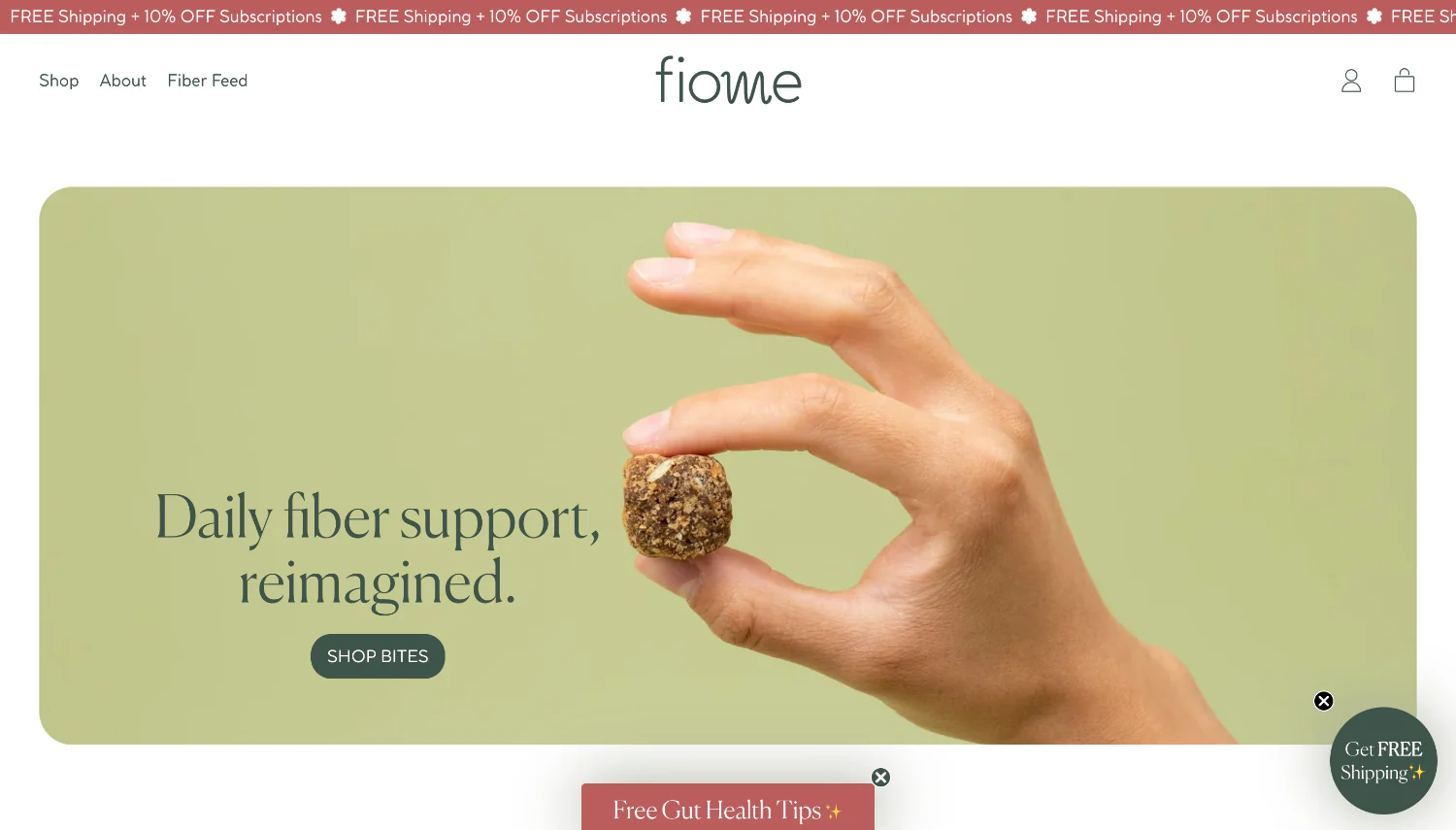 Fiome homepage featuring a hand holding a fiber bite against a soft green background.
