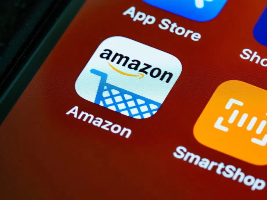 Close-up of a smartphone screen showing the Amazon app icon, featuring a shopping cart and the Amazon logo.