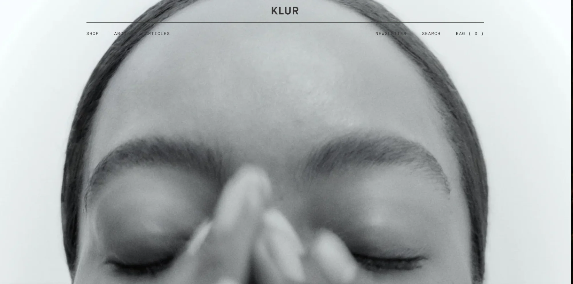 Klur’s homepage is simple and features a large image of a model applying a beauty product.