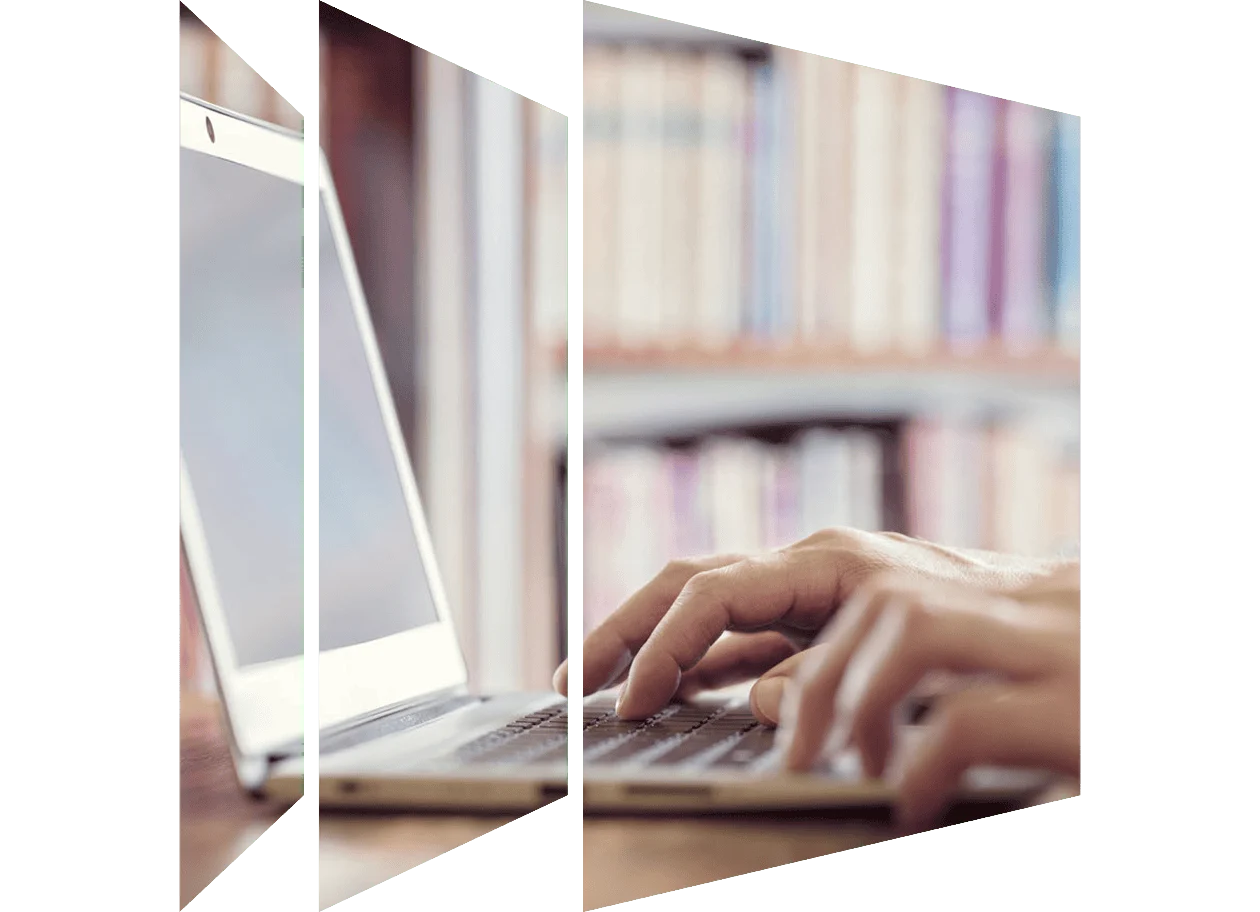 Hands typing on laptop computer in library