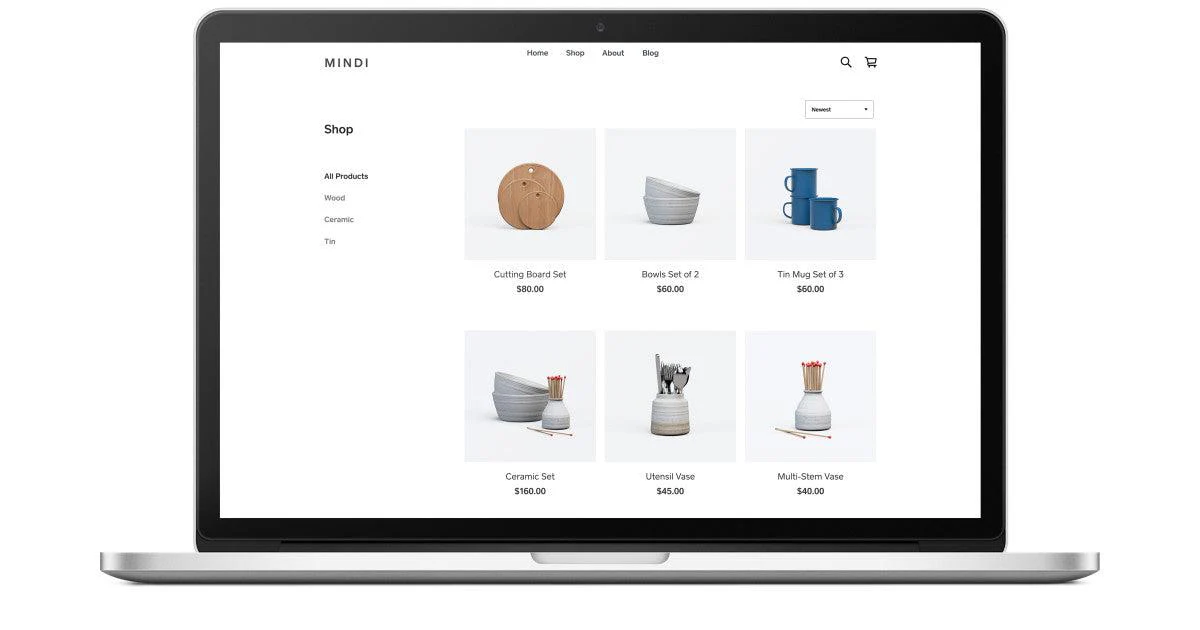 Online shop on a laptop screen showing ceramic and wooden home decor items with prices.