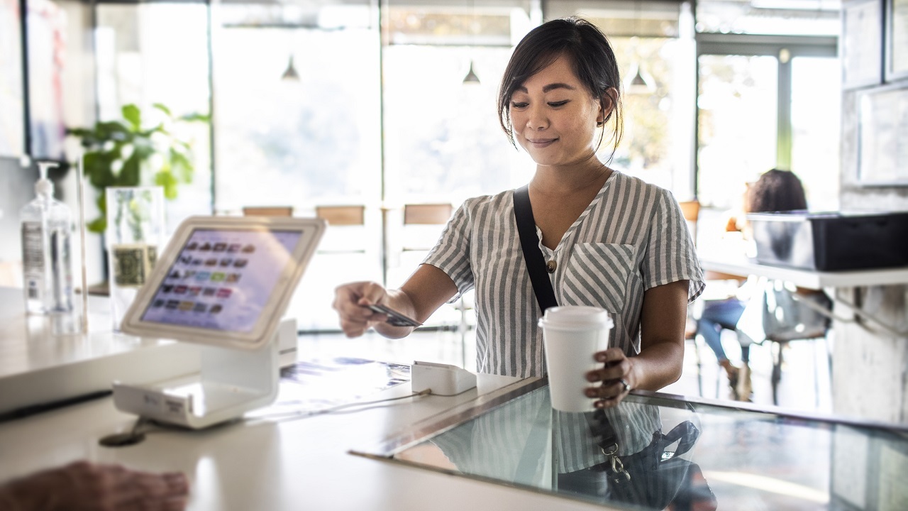 someone paying with their phone at the counter