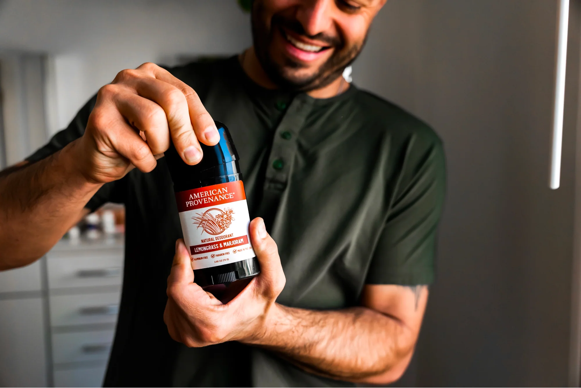 A person holds up a stick of American Provenance deodorant