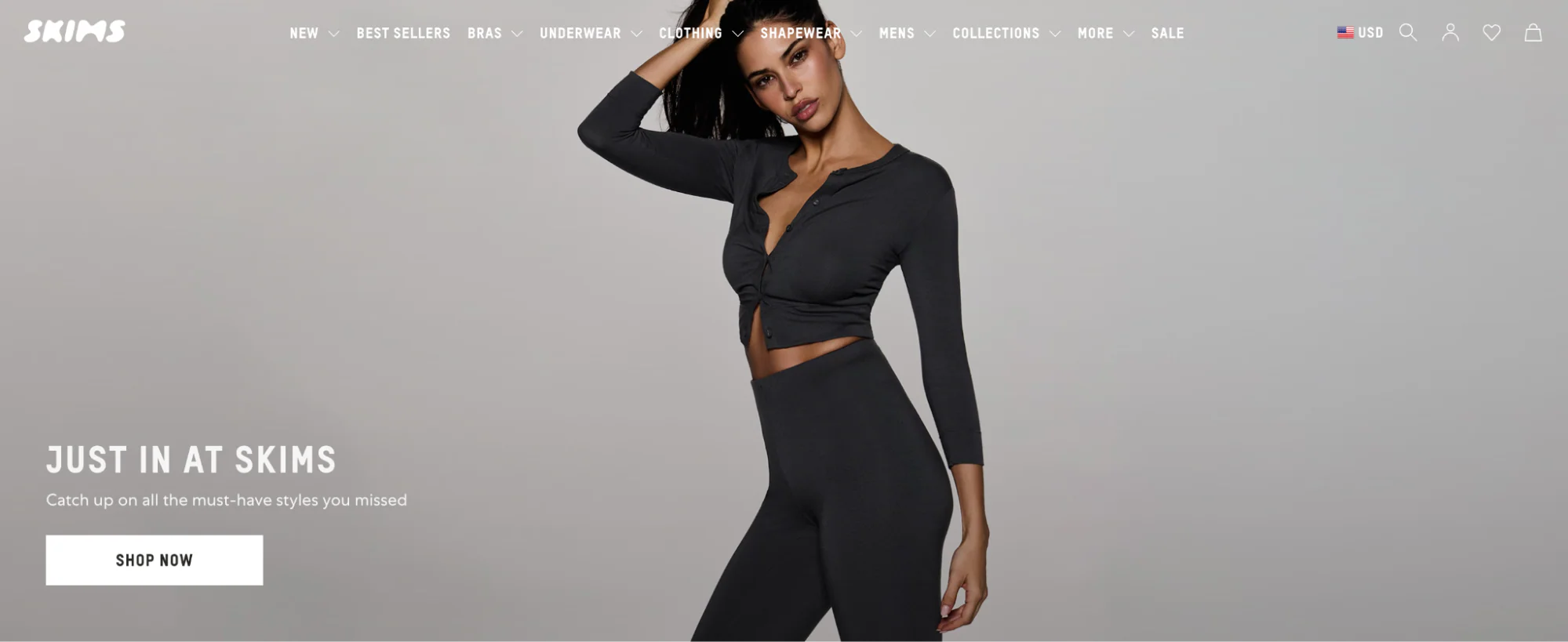 A model showcases black SKIMS clothing, featuring a cropped top and high-waisted leggings, with text promoting new arrivals on the website.