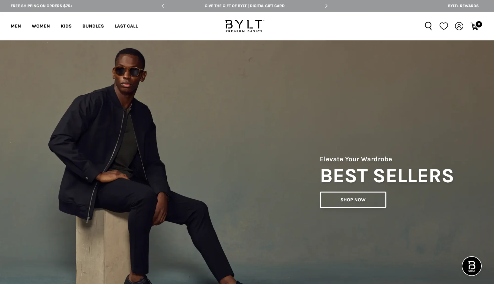 A model seated on a concrete block wears a dark jacket and pants, promoting "BEST SELLERS" and the message "Elevate Your Wardrobe" on the website.