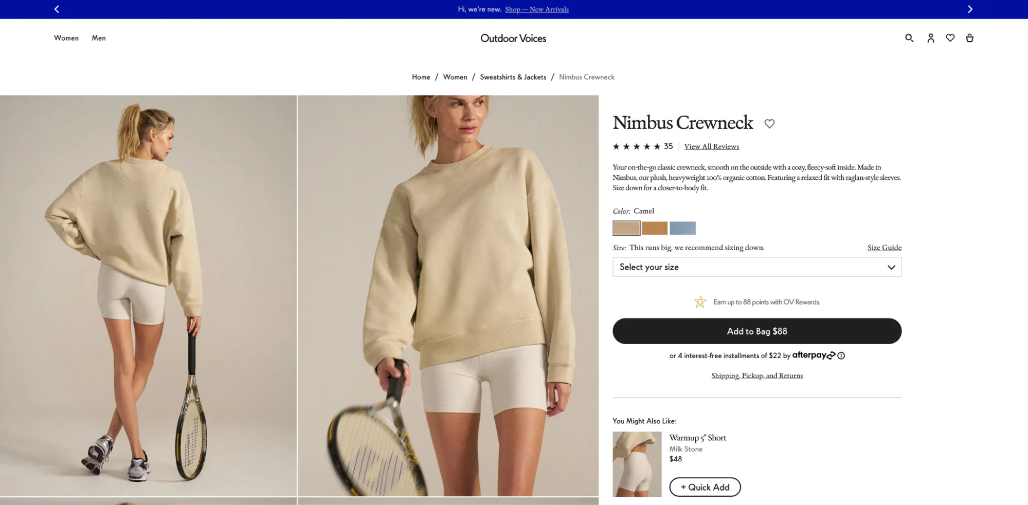 Product page of model in a crewneck sweatshirt while posing and holding a tennis racket.