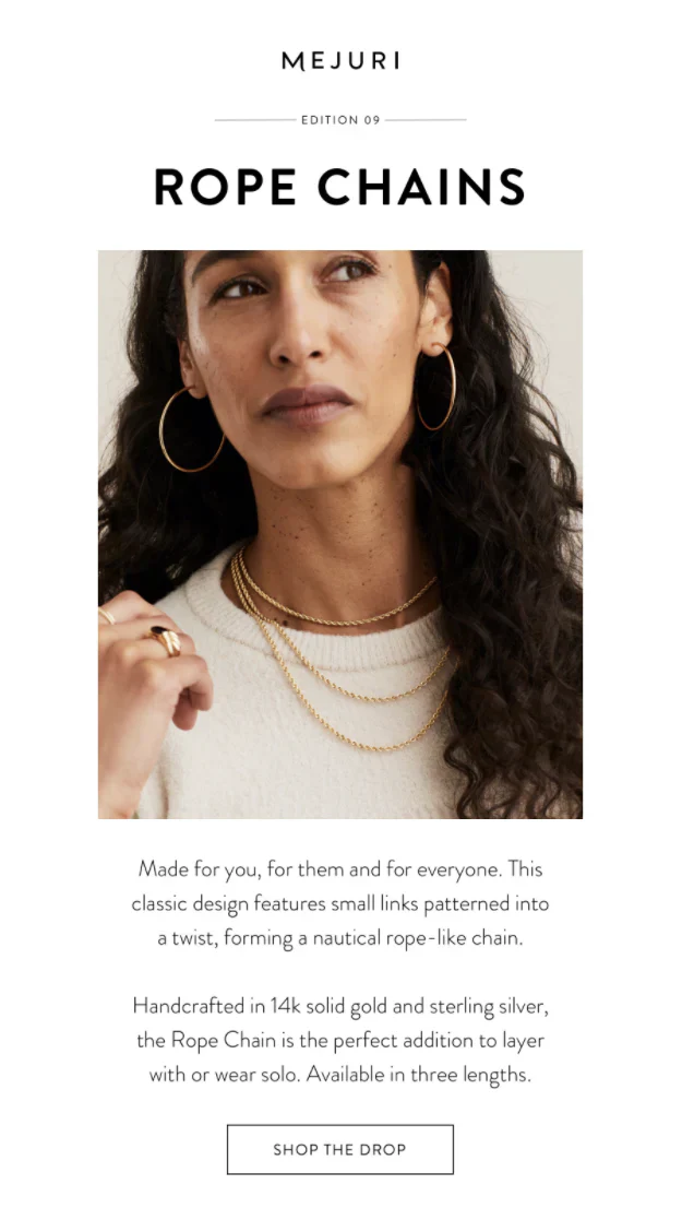 Brunette woman wearing fine gold jewelry against a white background.