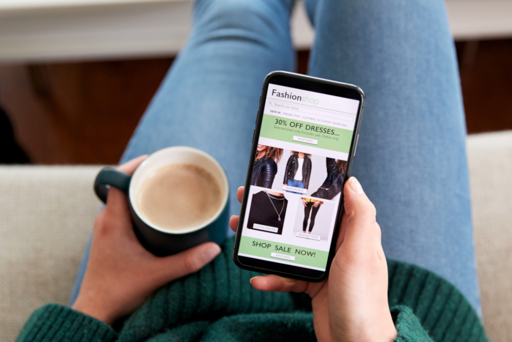 Close Up Of Woman Shopping For Clothes Online Using Mobile Phone App